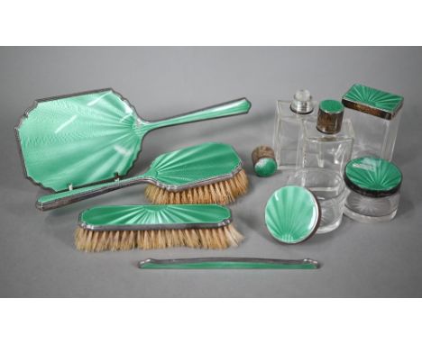 An Art deco silver and green guilloche enamel toilet set, comprising five jars and bottles and a four-piece brush set with mi