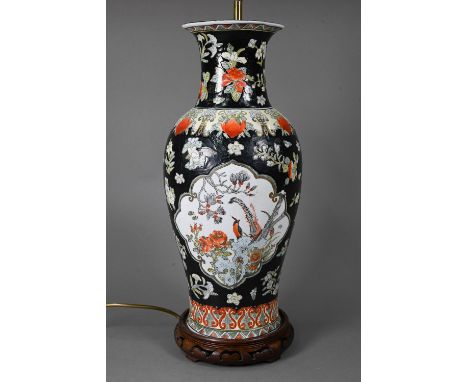 A late 19th or early 20th century Chinese famille noire style baluster vase (drilled and mounted as a lamp) on hardwood stand