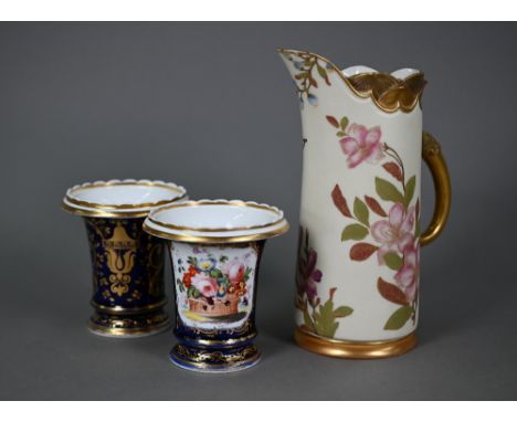 A pair of Regency porcelain spill-vases, the reserves painted with baskets of flowers on a blue and gilt ground, with flowere