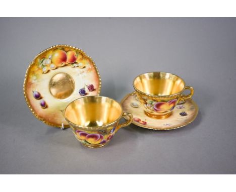 A pair of Royal Worcester cabinet tea cups and saucers, painted with fruit still lives, signed S. Wood - one saucer signed P.