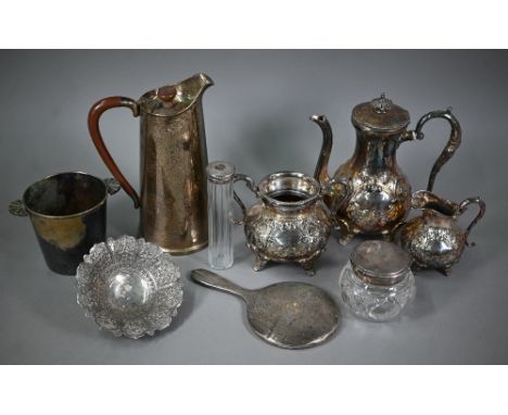 An Indian low-grade silver dish embossed and chased with foliage, 15cm diameter, to/w two silver-topped toilet jars and a sil