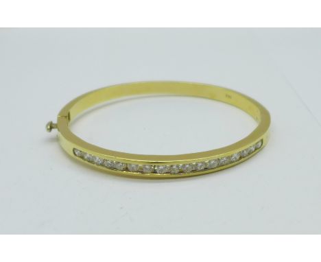 A 14ct gold and diamond bangle, set with seventeen diamonds, over 1 carat total diamond weight, 20.6g, (inner dimensions 58mm
