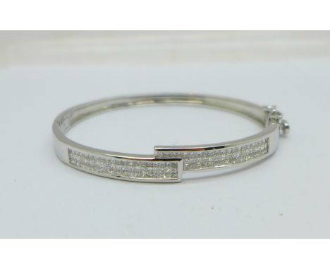 A 14ct white gold and diamond bangle, set with 124 square cut diamonds, 15.5g, (inner dimensions 50mm x 56mm) 
