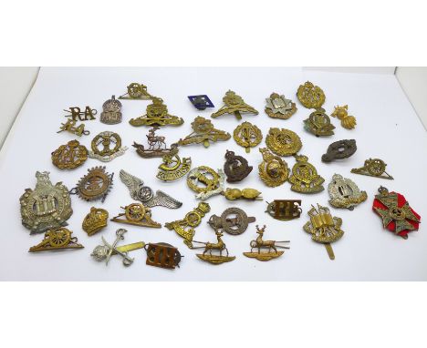 A collection of military badges including King's Own Scottish Borderers, American, East Surrey, Army Educational Corps, silve