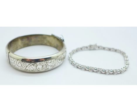 A silver bangle and a silver gem set tennis bracelet 