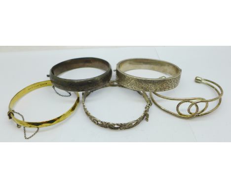 Four hallmarked silver bangles including one also marked '22ct on silver', and an open white metal bangle, total weight 85g 