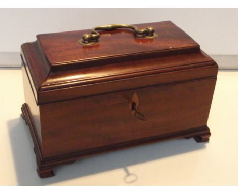 19th century mahogany tea caddy, sarcophagus form, the hinged lid with applied brass swing handle enclosing two compartments,
