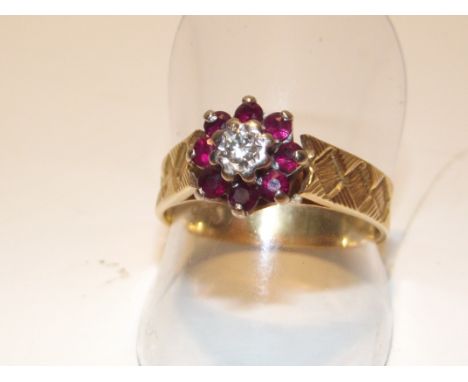 18ct yellow gold ring with 8 red stones surrounding and central diamond. Size Q