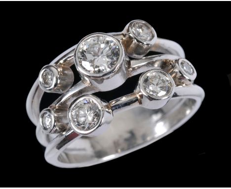A Contemporary Diamond Ring in the 'Raindance' style rub-over set seven brilliant-cut stones to triple shank, total diamond w