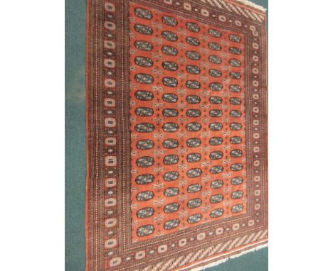 A multi-bordered Turcoman type Carpet with five rows of fourteen small guls on a brick red ground, 9ft x 6ft 4in