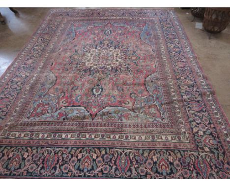 An Oriental woollen Carpet with central flower head on pale blue ground within multiple borders with floral decoration, 12ft 