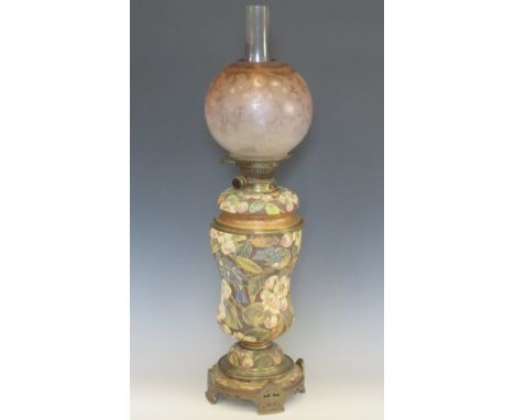 An Edwardian Oil Lamp, the ceramic base painted tits amongst blossom, bronzed metal mounts with floral engraved pink tinted g
