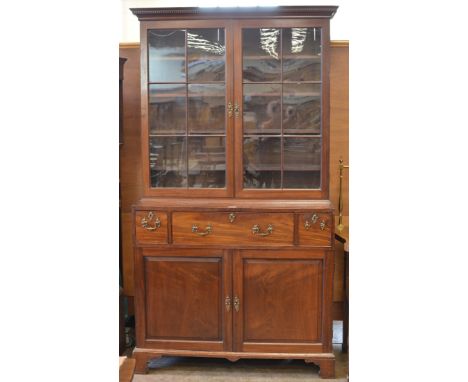 An 18th Century mahogany Library Bookcase, the dentil moulded cornice above a pair of glazed doors enclosing adjustable shelv