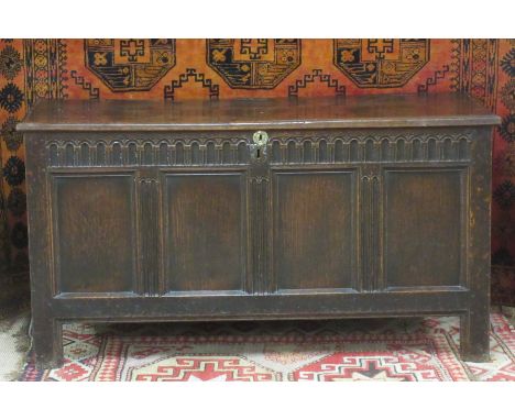 A 17th Century oak four panel Coffer with split pin hinged two plank lid enclosing a candlebox, the front decorated with knul