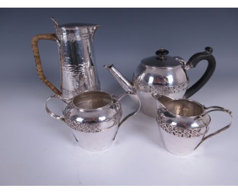 A George V Arts &amp; Crafts silver three piece Tea Service with hammered design and Celtic style strapwork frieze, London 19