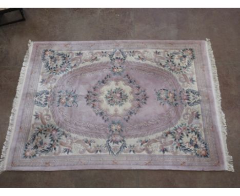 A bordered Chinese Carpet with large central floral medallion on pink ground, leafage embossed border, 13ft x 9ft