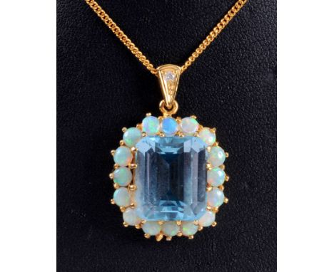 A Blue Topaz and Opal Pendant, the step-cut blue topaz claw-set within a frame of cabochon opals, the gold hanging loop set s