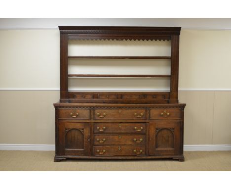 An antique oak Dresser and Rack, the shelves with shaped frieze, fluted pilasters and fitted four small spice drawers, the en
