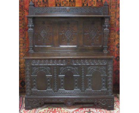 A 17th Century oak Joined Chest with later raised three panel back above hinged lid, the box chest base decorated with three 