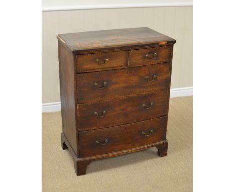 A late Georgian mahogany Chest of two short and three long bow front drawers with chevron and chequered stringing on bracket 