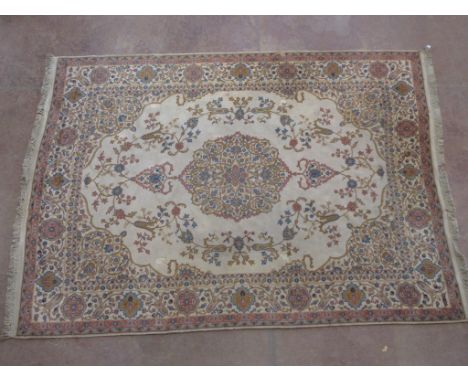 A bordered Turkey type Carpet with central floral oval medallion and spandrels in blue, brown, pink on a camel ground, the ma