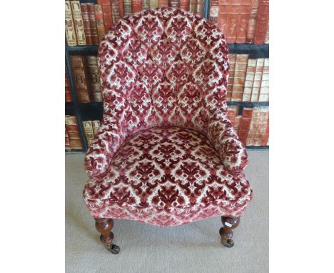 A 19thC nursing chair with turned front legs and button back