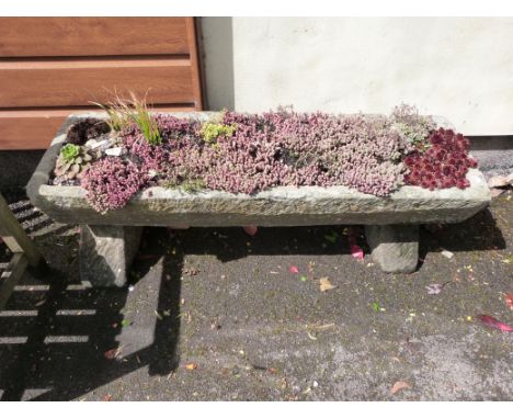 A natural stone trough on stand