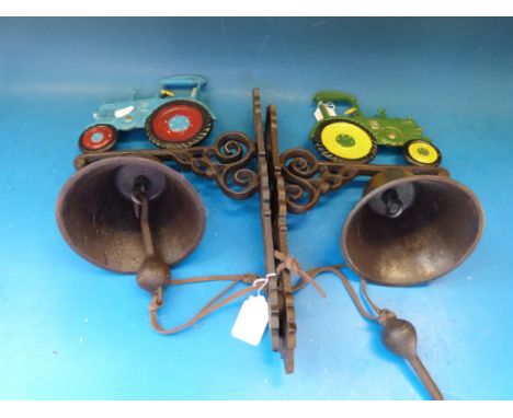 Two wall mounted cast bells with vintage tractor atop 