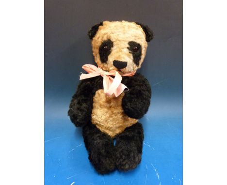 A vintage panda bear with jointed limbs probably Merrythought or Chiltern Hygienic Toys, 36cm tall. 