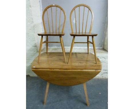 An Ercol light elm table and six chairs