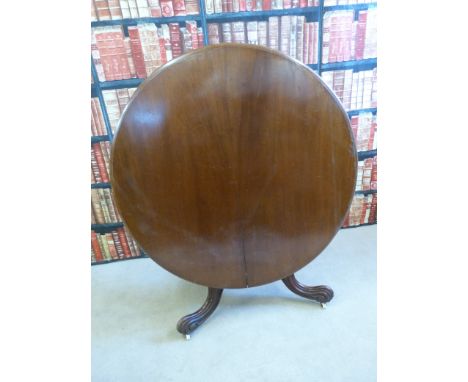 A 19thC mahogany tilt top circular breakfast table raised on a scrolling tripod base and a ceramic castors  (Diameter 117, H7