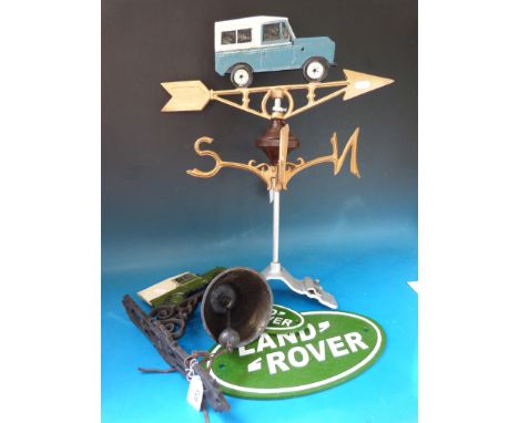 A Land Rover wall mounted bell, two Land Rover signs and a Land Rover weather vane (largest 35cm wide)