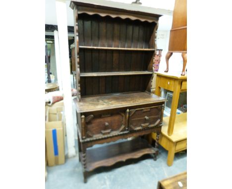 An oak dresser with plate rack top the base with cupboard and shelf below (W107, D42, H186cm) 