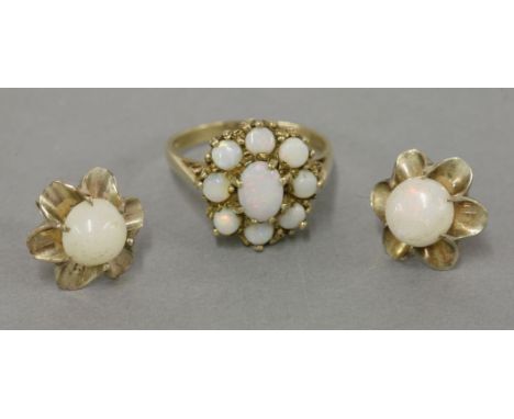 A 9ct gold opal cluster ring, and a pair of matched single stone cabochon opal earrings, tested as approximately 9ct gold