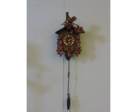 A Bavarian carved soft wood wall mounted cuckoo clock, with damage, 52cm high