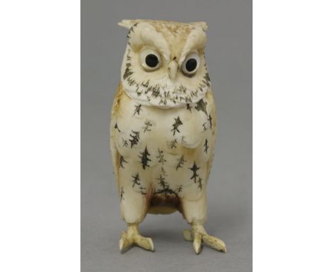 An early 20th century bone owl, carved in standing pose with engraved and painted feathers, the head with 'ears', scowling ey
