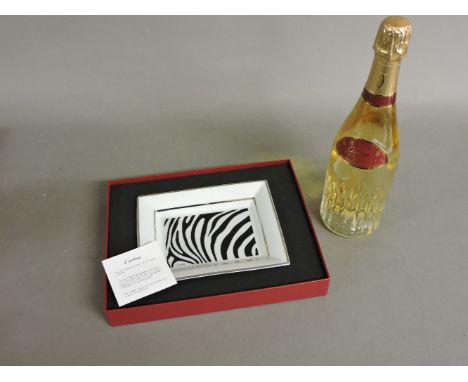 A Cartier trinket tray, and a bottle of Cartier champagne