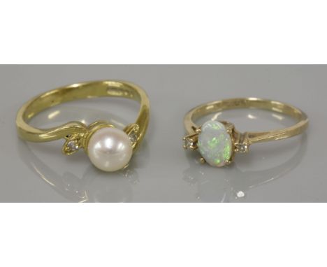 An 18ct gold single stone cultured pearl crossover ring, with diamond set leaf shoulders, and a three stone opal and diamond 