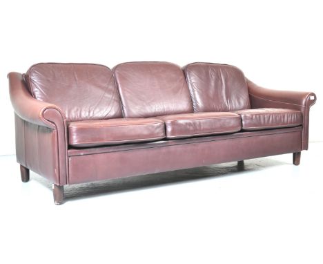 A 1970's Danish Scandinavian retro vintage red cognac leather rolled arm three seat sofa settee having three cushions to back