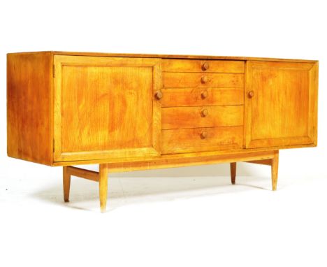 A 1960's unusual retro vintage elm wood sideboard credenza comprising of a central bank of five graduating drawers flanked by