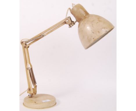 A 20th century retro vintage anglepoise desk lamp in a cream colourway being raised on a circular terraced base with adjustab