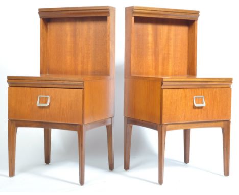 A pair of 1970's retro vintage teak bedside cabinets having tall panel back and single door cupboards with metal pull handles