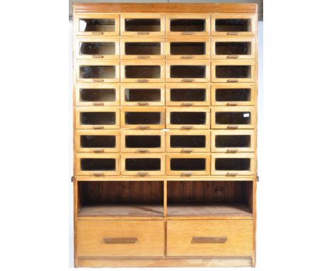 A stunning early to mid 20th century haberdashery multi drawers shop display wall unit in teak with oak panelling. The cabine