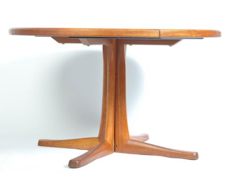A. H . Mcintosh of Kirkcaldy - A 1970's retro vintage teak wood extending round pedestal dining table having the four splayed