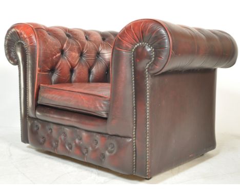 A retro vintage ox blood leather chesterfield armchair with a barrel rolled arms and backrest being button backed. The front 