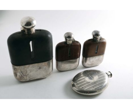 A VICTORIAN ELECTROPLATED OVAL SPIRIT FLASK with engine-turned decoration and three other plated-mounted glass spirit flasks 