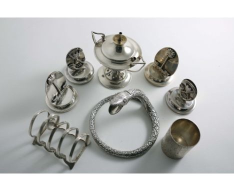 A MIXED LOT:- An Edwardian serpent cigar cutter (originally mounted on a dish or ash tray), a toast rack, a textured measure 