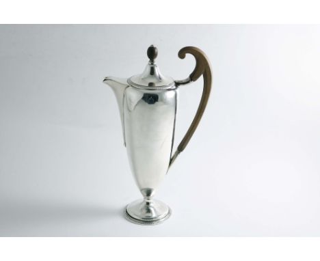 AN EARLY 20TH CENTURY HOT WATER JUG of slender vase form with an upswept scroll handle, a rising cover and ball finial, by Jo