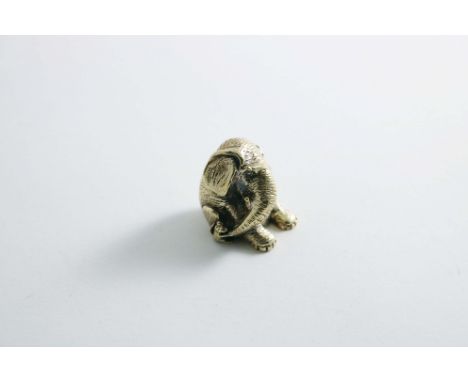A LATE 20TH CENTURY CAST SILVERGILT MINIATURE FIGURE OF AN ELEPHANT slumped on its haunches, with a mouse tugging at his trun