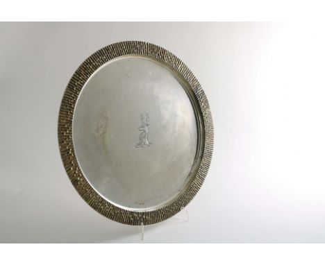 A LATE 20TH CENTURY PARCELGILTY SALVER OR TRAY of plain circular outline with a stepped, textured border, the centre engraved
